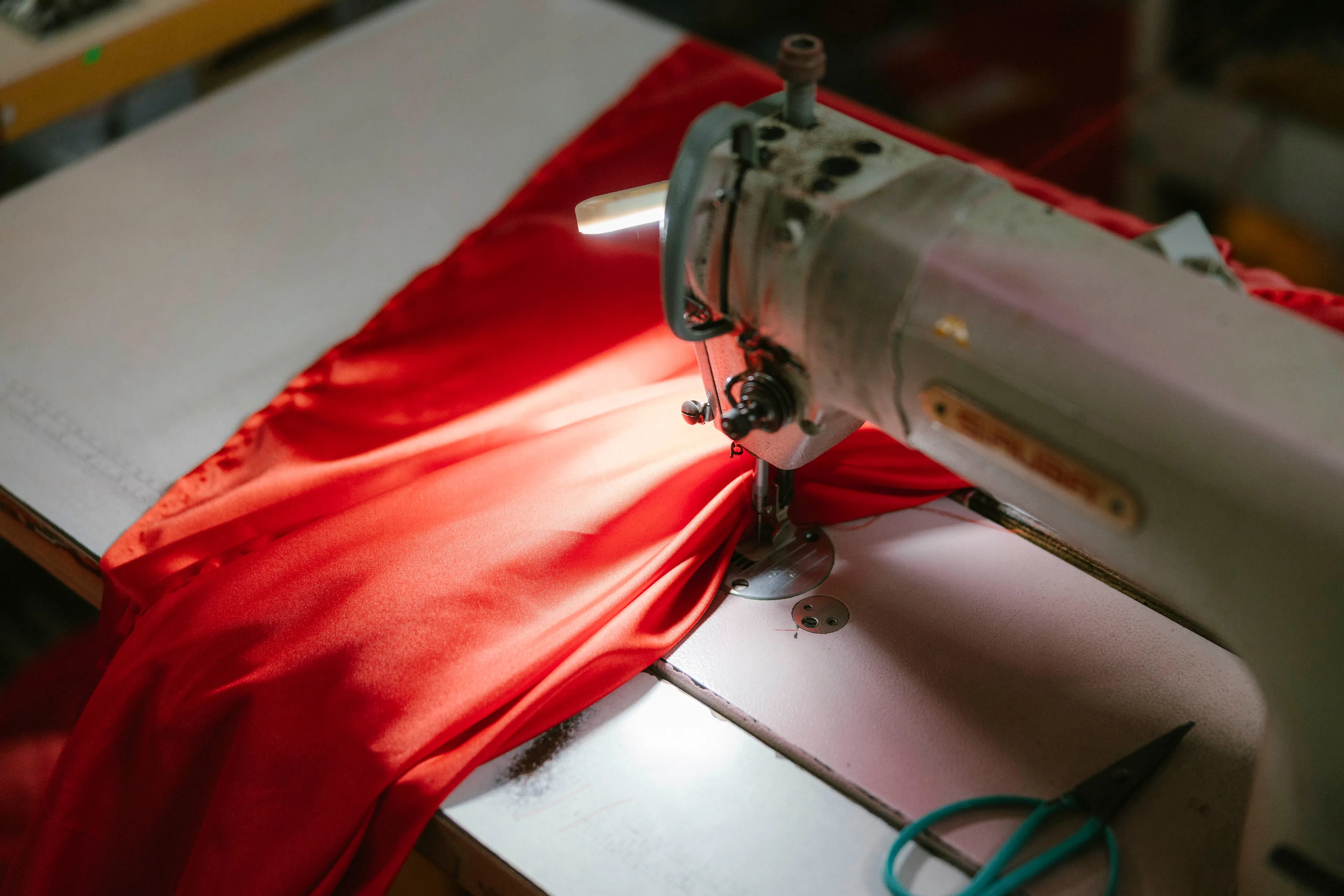 Competitive streak in Home Economics, showing a sewing machine with a bright red fabric being stitched, highlighting creativity.