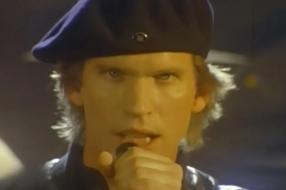 Survivor's Eye of the Tiger: A band member sings passionately into a microphone, a song that feels like life.
