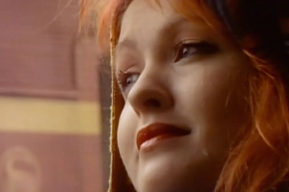 Cyndi Lauper with red hair and a tear on her cheek, representing a song that feels like your life.