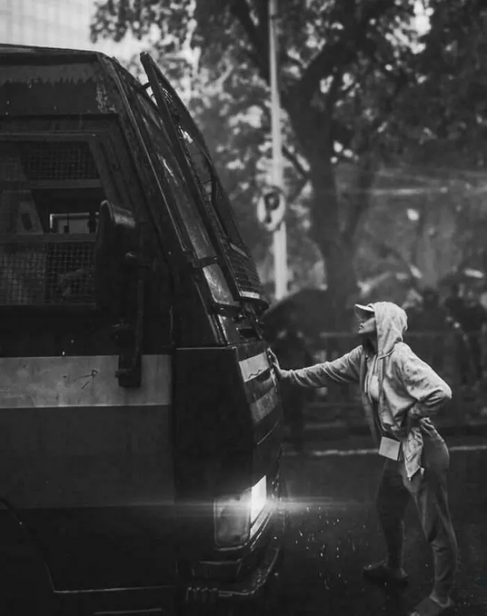 A Young Woman Singlehandedly Stopping A Police Truck In Peak Monsoon During Countrywide Mass Protests Demanding Education Reforms (Mumbai, India)