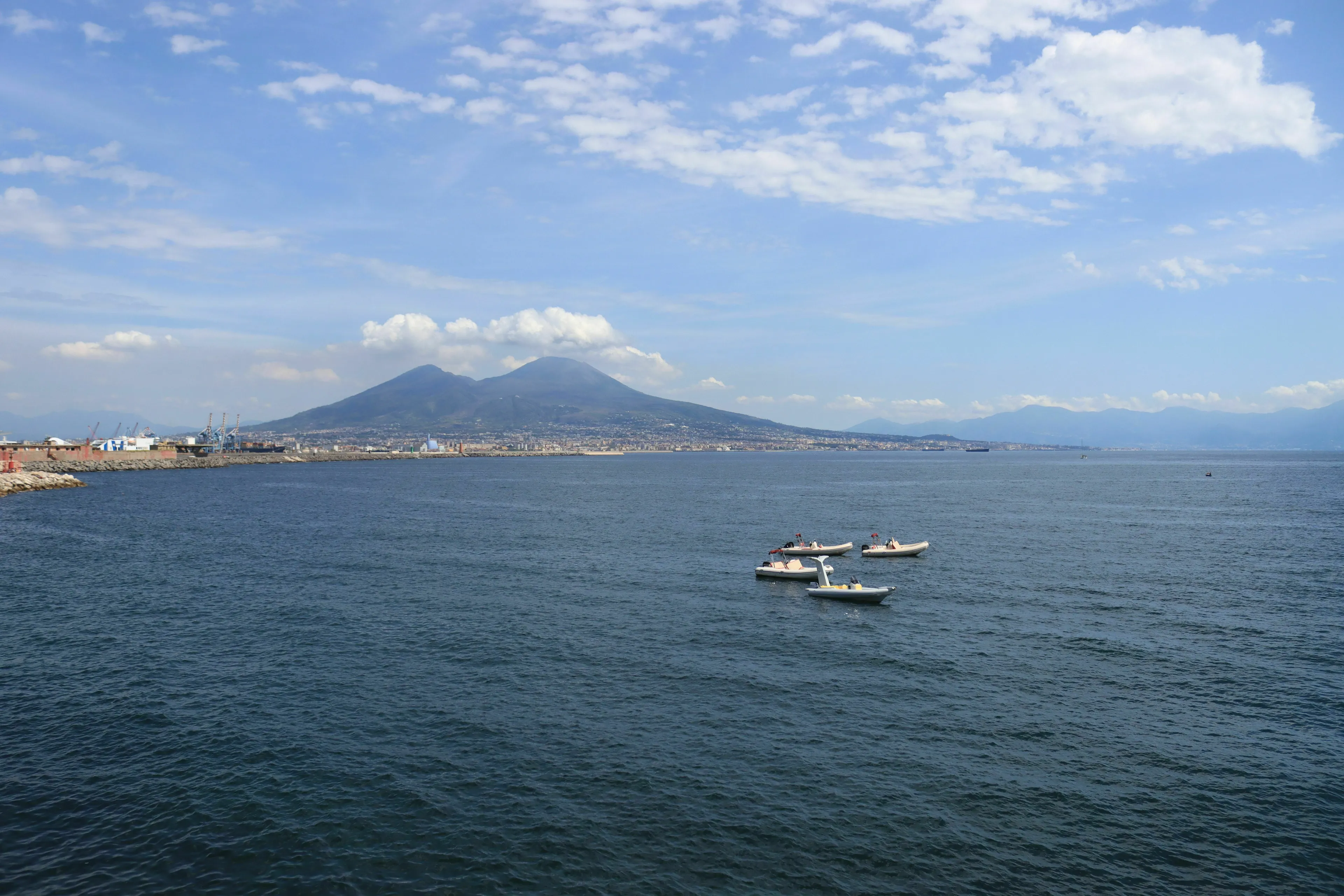 Mount Vesuvius overlooking the Bay of Naples, with small boats on the water, for a geography knowledge quiz.