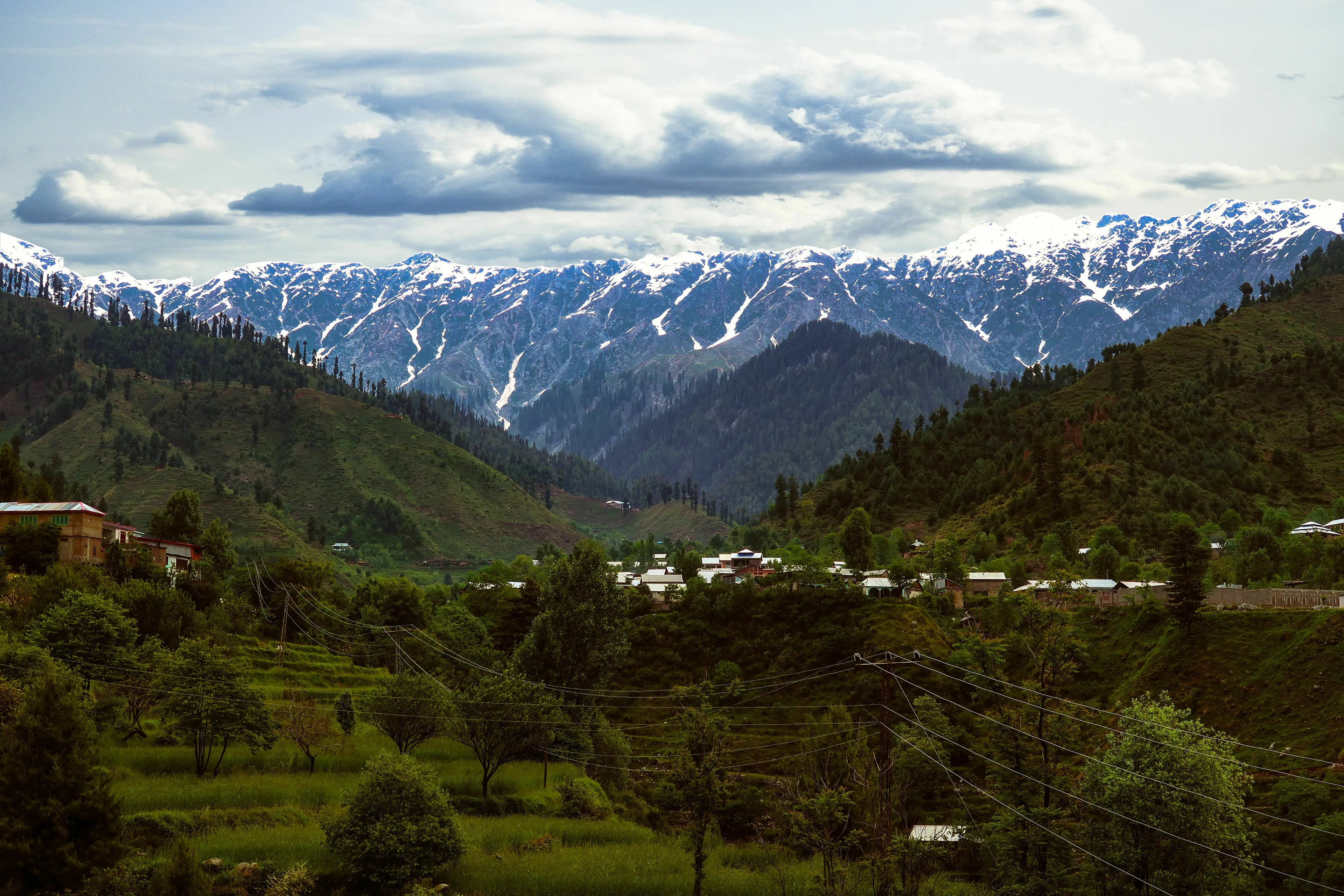 Panoramic view of mountains in Pakistan, featuring snow-capped peaks and lush green valleys. General geography knowledge quiz.