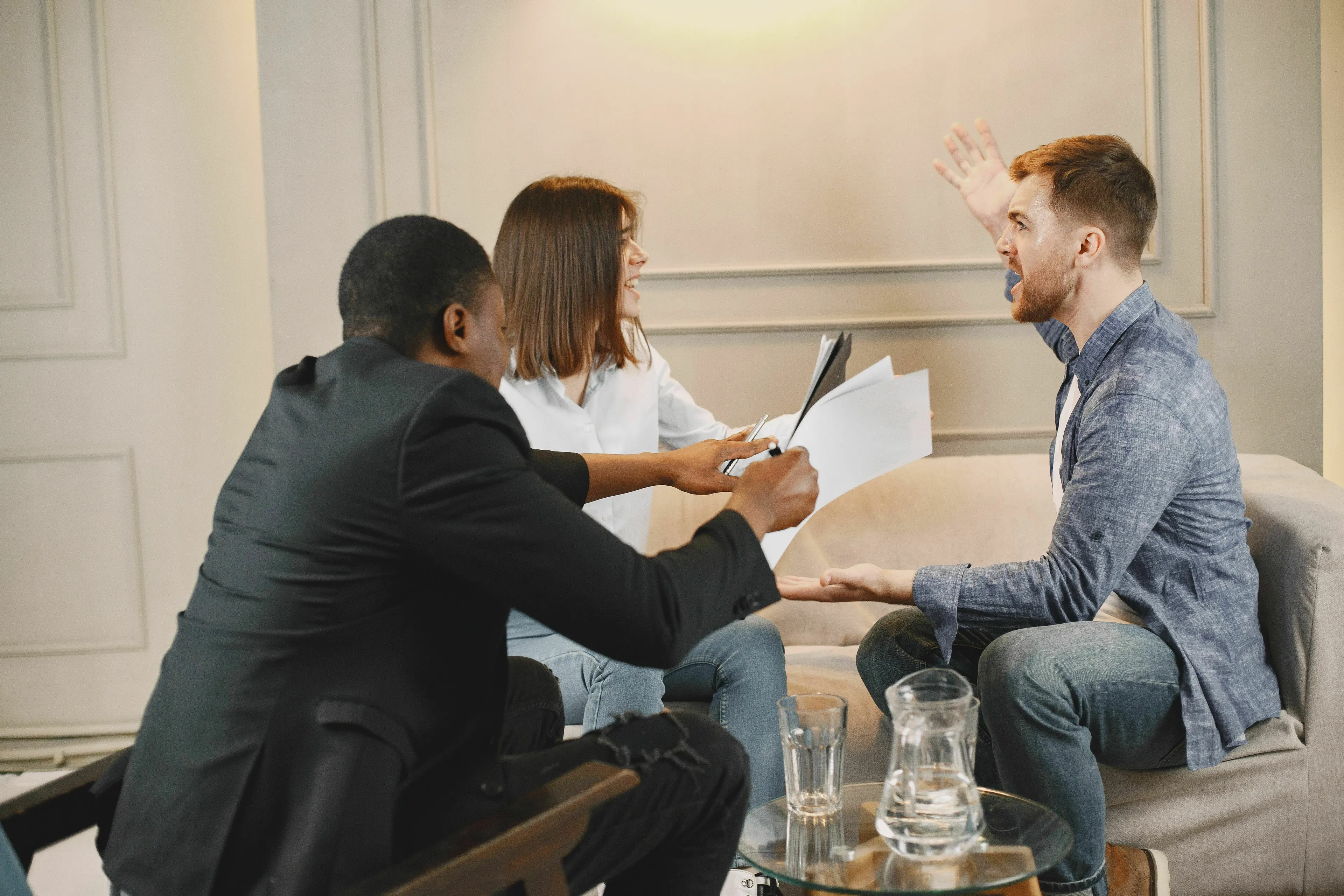 Three people discussing with one man gesturing, depicting how you deal with a disagreement for your born decade.