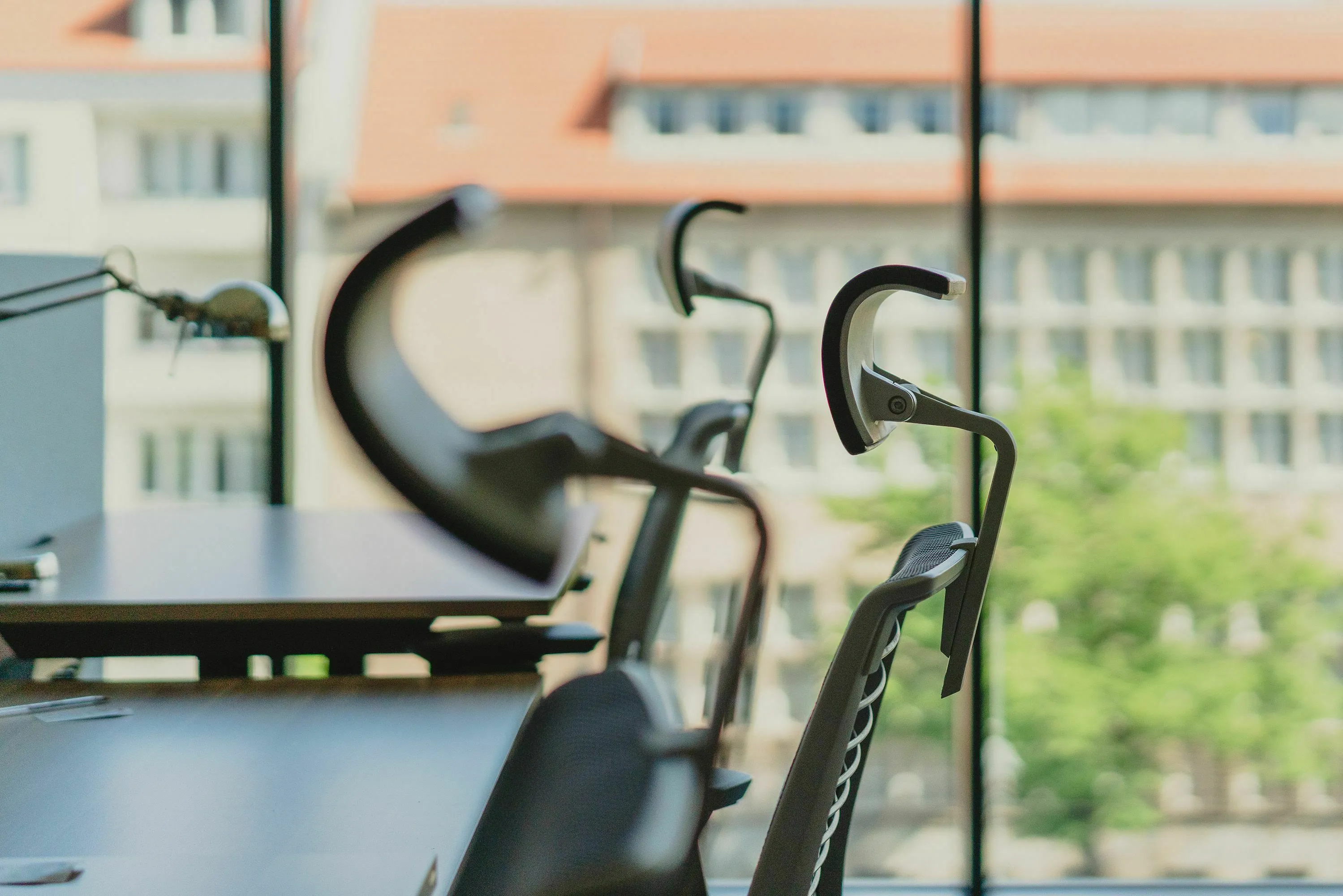 Historical figure's ideal workspace with modern office chairs and a view of city buildings.