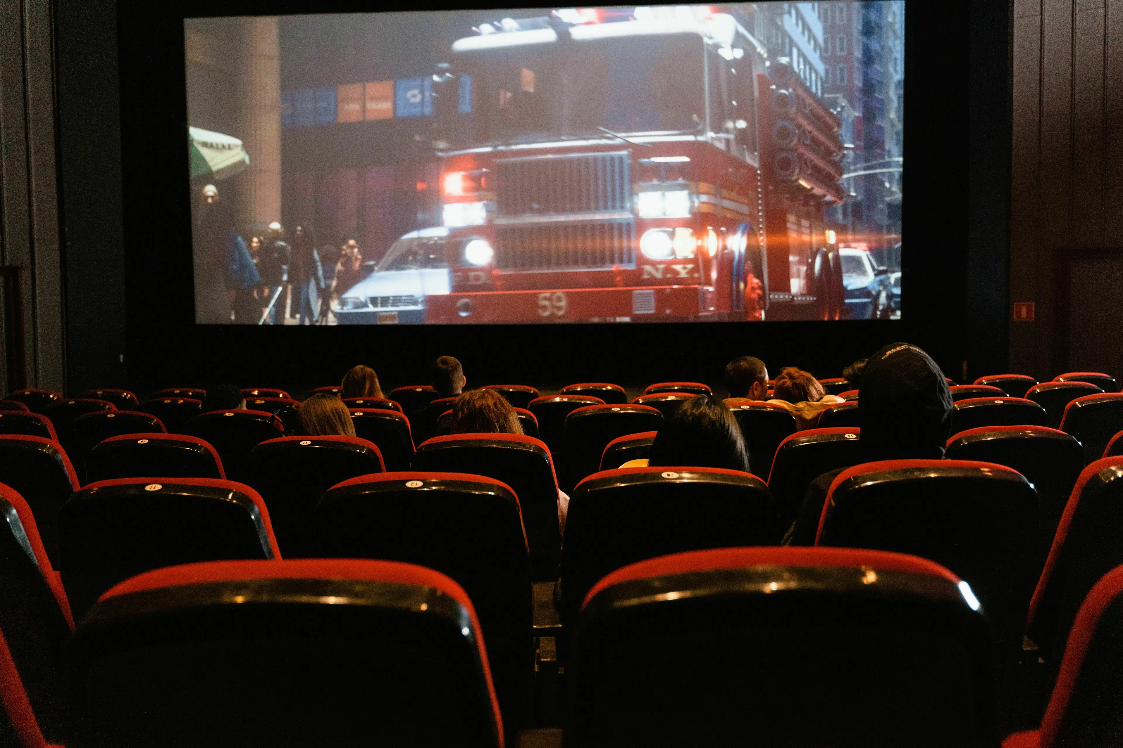 People watching a movie at a cinema, a Brit watches a film and an American watches a movie.