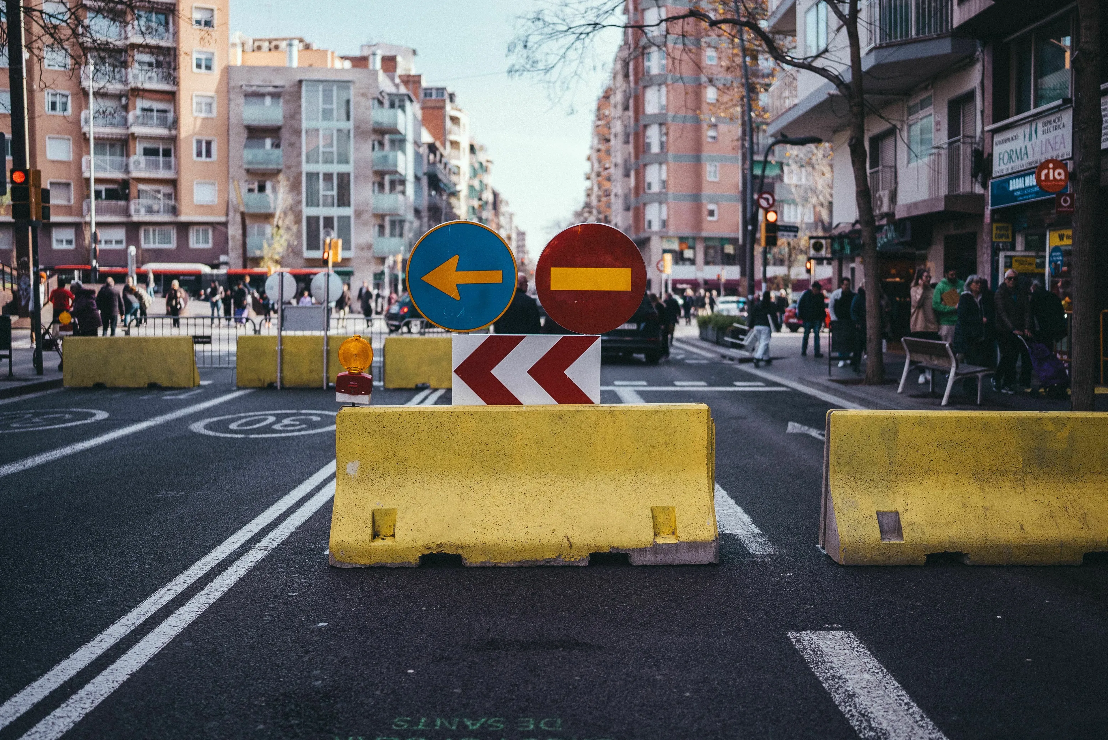 A city street with yellow barriers and road closed signs, for an English words quiz about road closures.