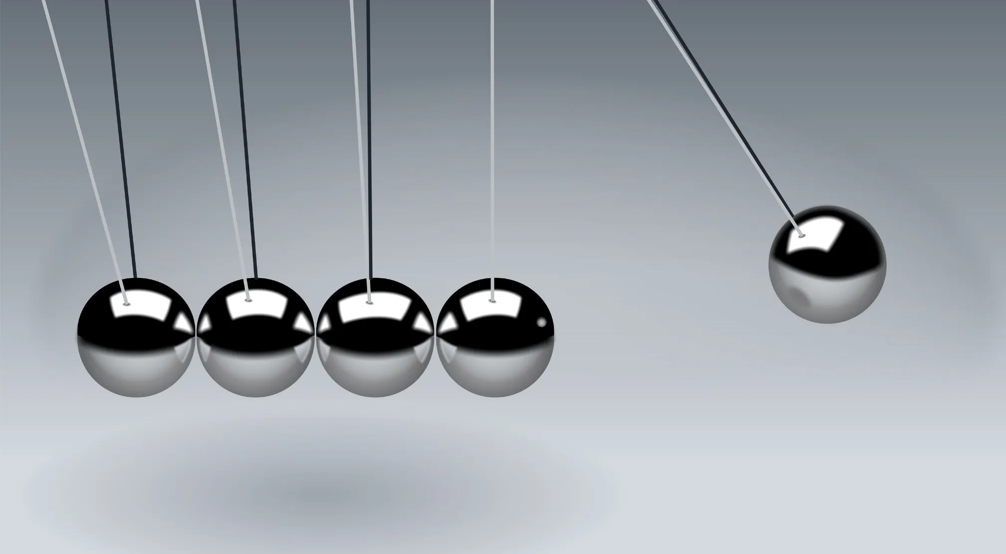 Newton's Cradle, five metallic spheres on a light grey background, illustrating momentum and kinetic energy transfer.