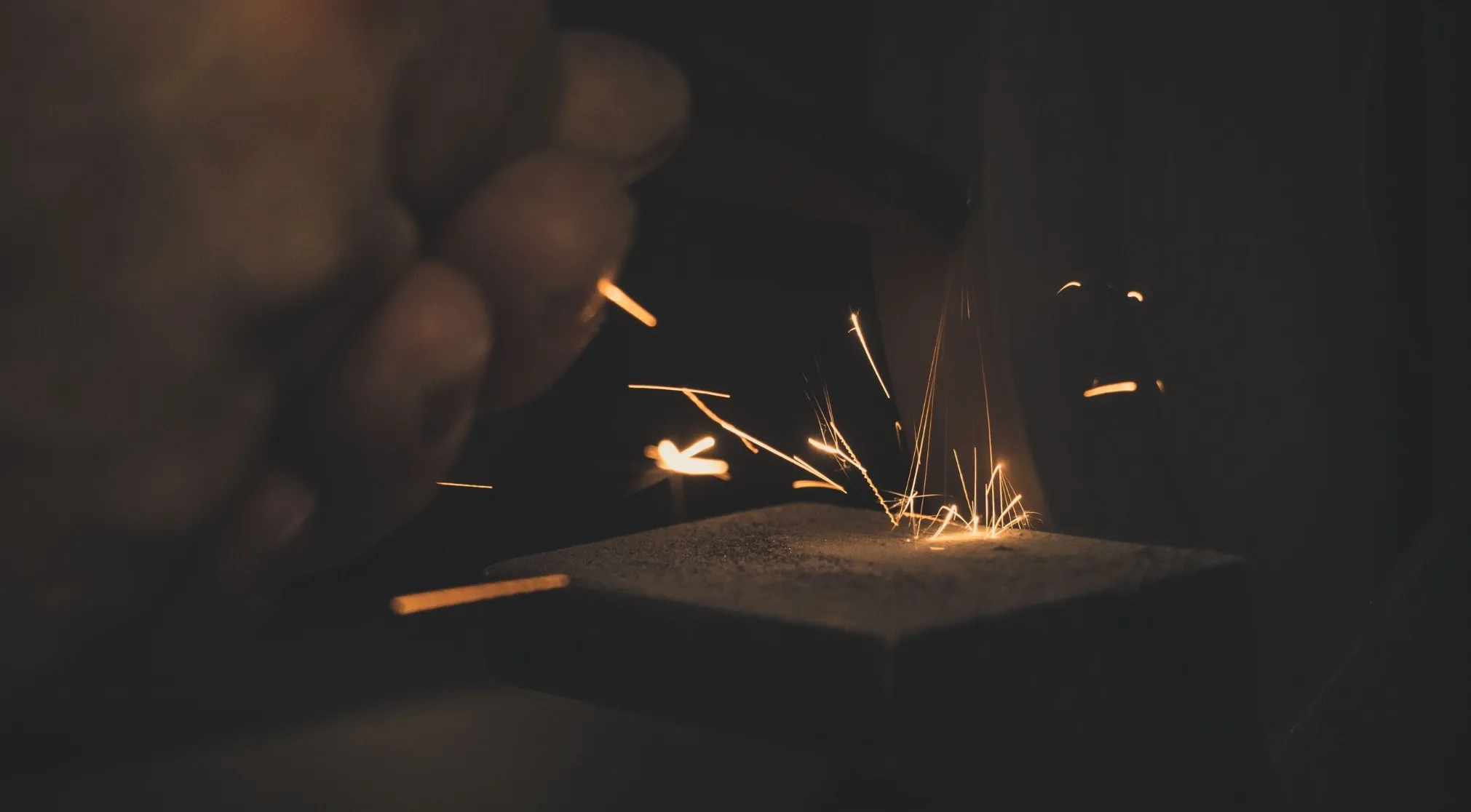 Close-up of sparks flying from an object, highlighting the concept of friction and energy. Would FBI hire you?