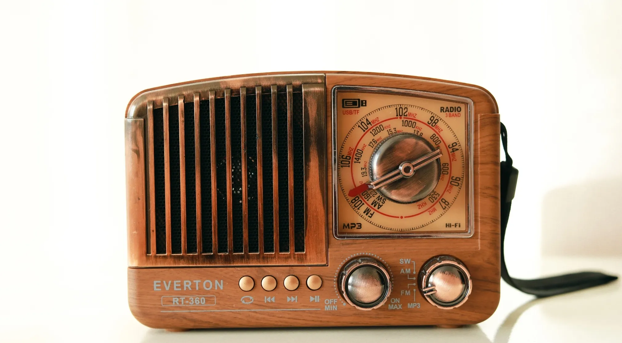An old-fashioned wooden radio, with a speaker grill and tuning dial, produces sound energy and heat energy.