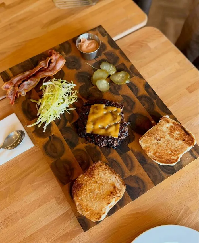 Deconstructed cheeseburger served on a wooden board showcasing questionable food combos.