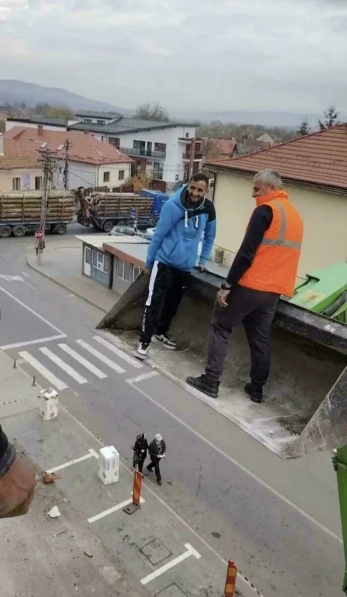 Two men appearing to stand on a tilted section of road or building, an optical illusion caused by perspective. Real photos that make your brain question if they were edited.