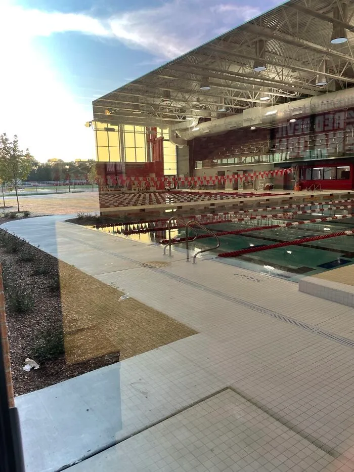 Real photos of an indoor swimming pool reflecting outdoor scenery, making the brain question if they were edited.
