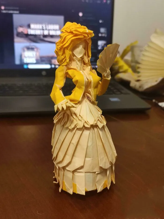 An Origami Woman In Dress Folded From A Single Square Of Paper
