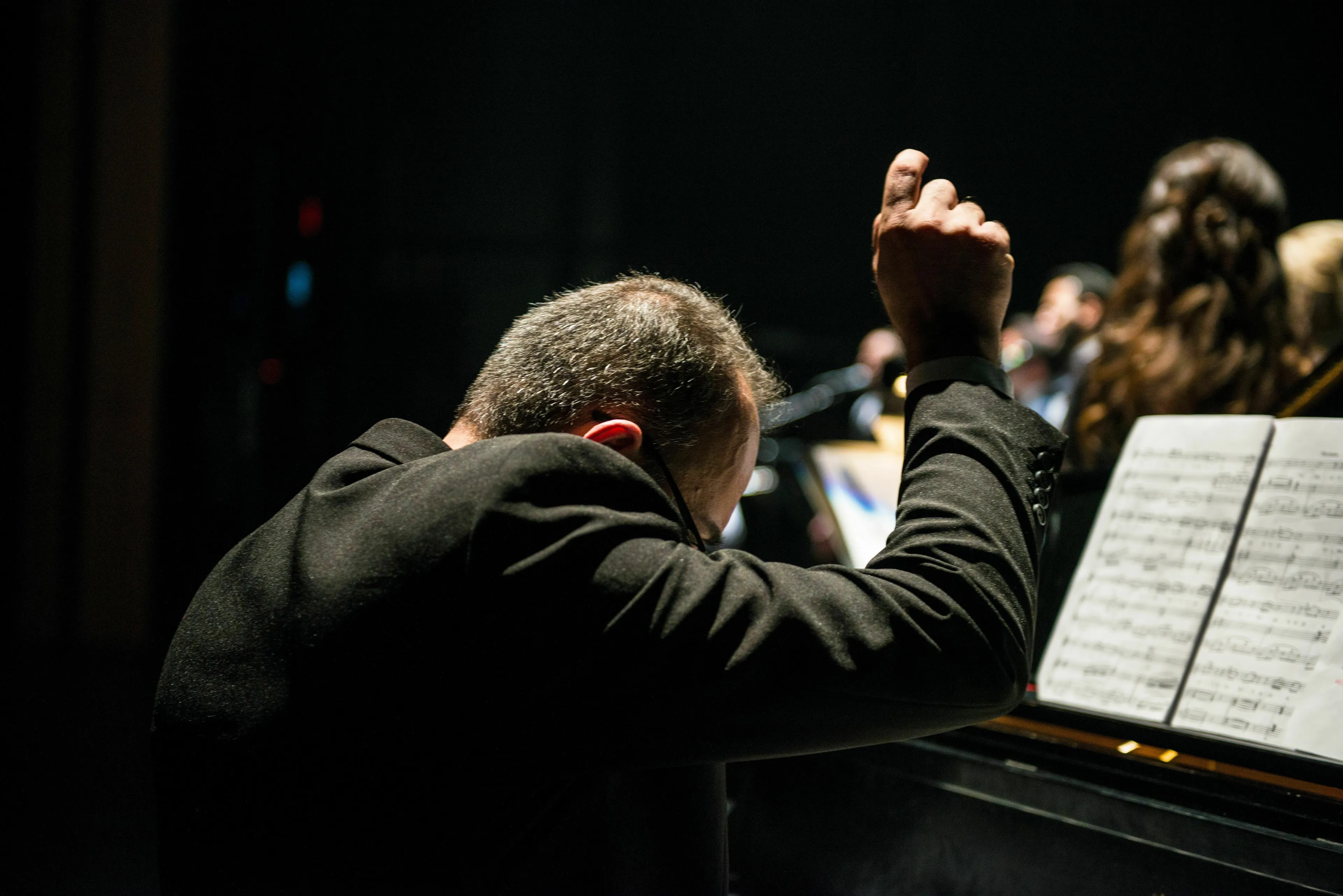 A conductor leads an orchestra, illustrating a classical music quiz about musical terms.