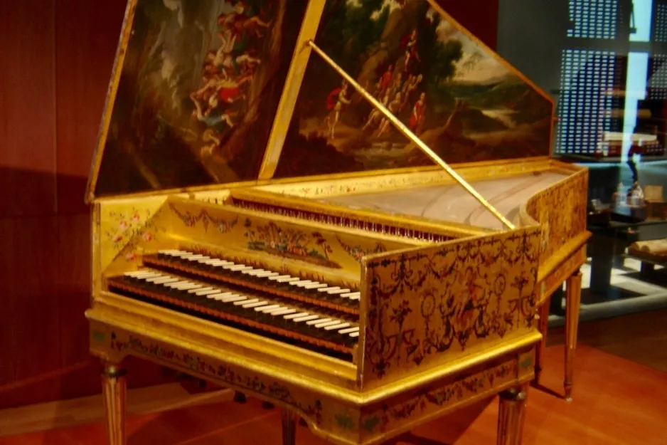 A Harpsichord custom-built to adapt to the architecture, with ornate golden decorations and painted lid.