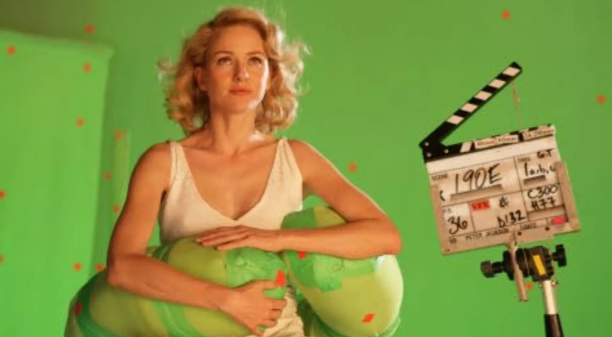 Blonde actress on a green screen BTS image set, holding a green object, with a clapper board showing Peter Jackson.
