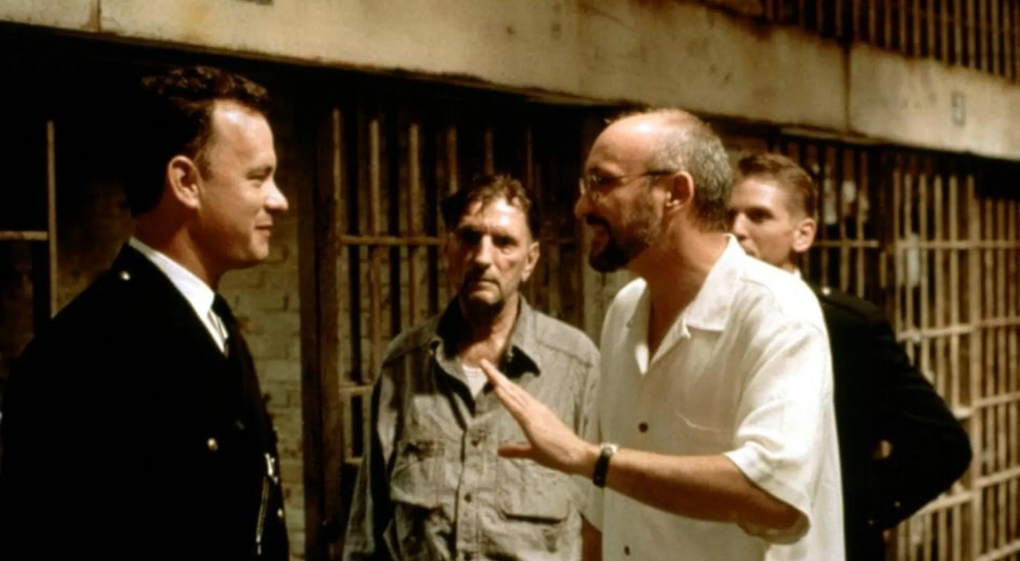 BTS image from a movie set, showing a director and actors in a prison scene. Guess the movie from this snapshot.
