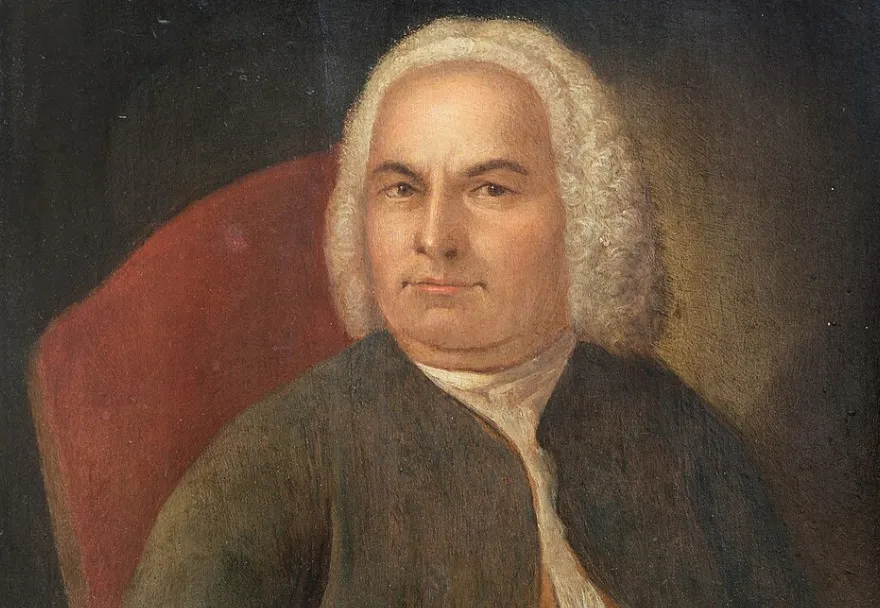 Portrait of Johann Sebastian Bach, the famous composer, with a white wig, dark coat, and a serious expression.