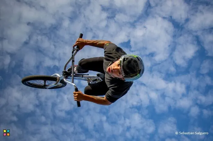 Award-worthy photo of a BMX rider performing an aerial trick against a blue sky, telling a story of freedom.