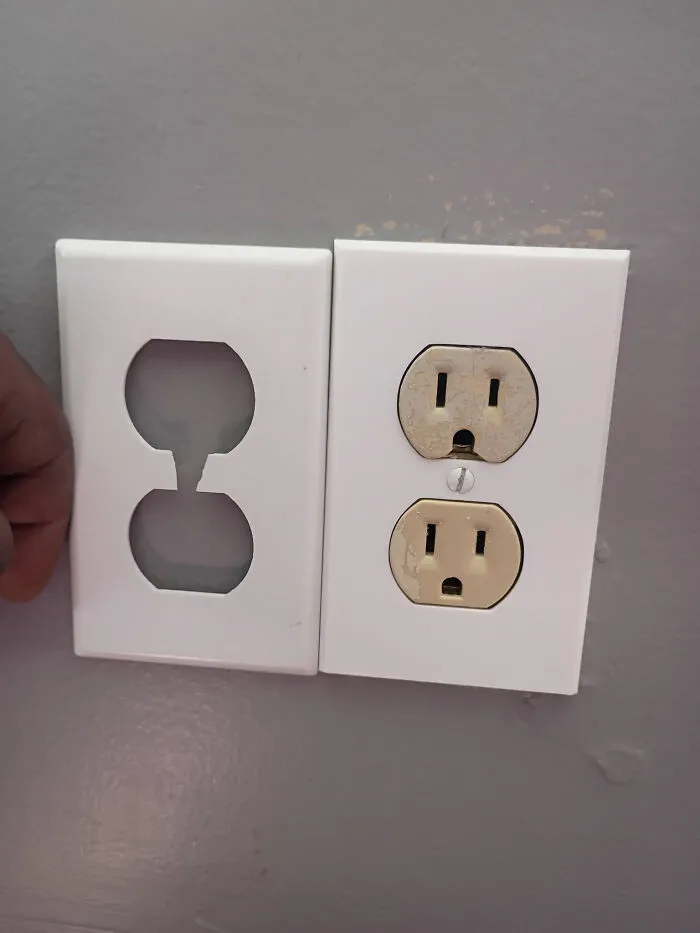 A white 3D printed wall plate next to an electrical outlet, ready for installation.