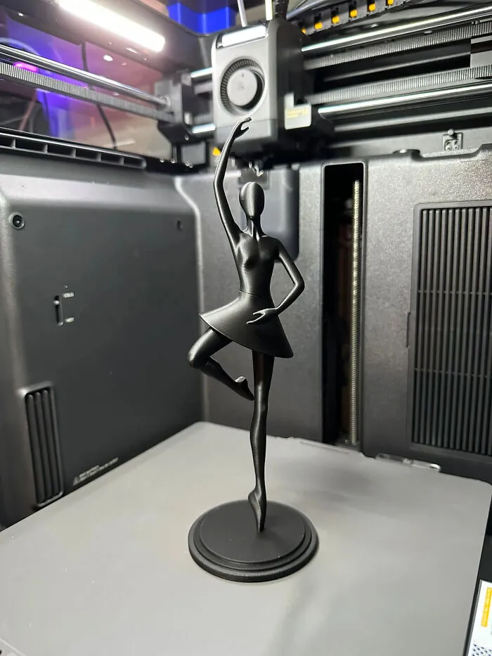 A black ballerina figurine, a cool and useful thing created with a 3D printer, standing gracefully.