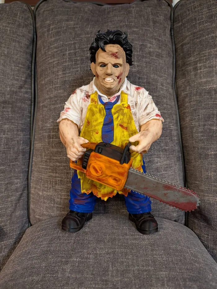 A Leatherface figurine holding a chainsaw, a cool and useful thing created with a 3D printer.