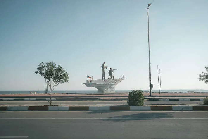 A monument depicting figures on a boat by the Strait of Hormuz, symbolizing the human aspect of the area.