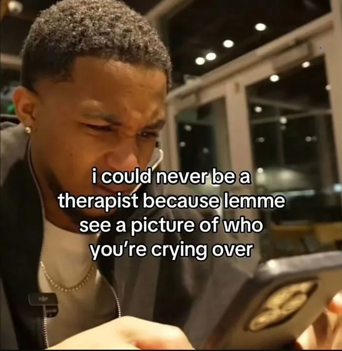 A man looking at his phone with a relatable meme about wanting to see a picture of who someone is crying over.