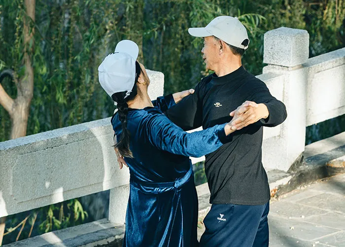 Older generations couple dancing outdoors, a recreational activity many have stopped doing.