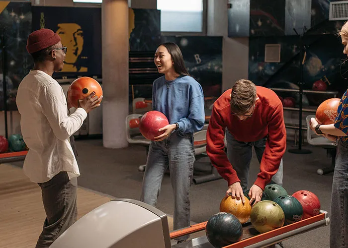 Friends enjoying a game of bowling, an activity many generations used to do more often.