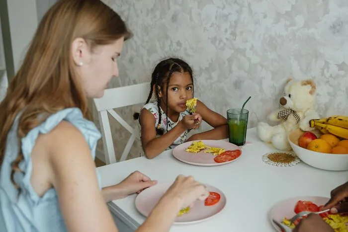 A mother and child eating, depicting family life and the impact of under my roof rules on children.