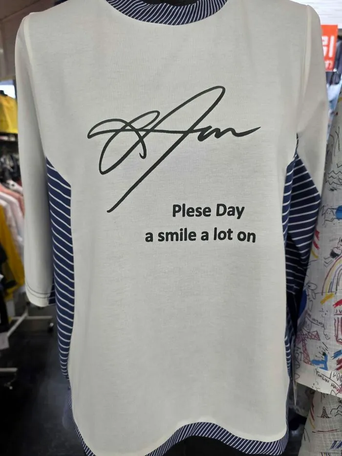 Hilarious example of getting lost in translation: a shirt in Japan with text that reads Plese Day a smile a lot on.