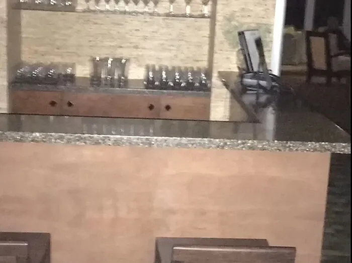 A dimly lit bar area with glasses on shelves, hinting at unexplained phenomena in ghost videos.