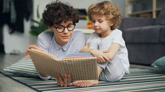 A parent and child read a book, illustrating a time parents were terrified of their own children.
