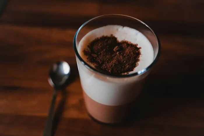 A glass of layered drink with cocoa powder, symbolizing a partner giving an ick they can't get over.