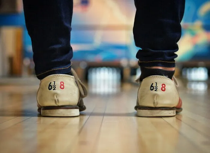 Bowling shoes on a lane, illustrating men giving partners an ick they can't get over.