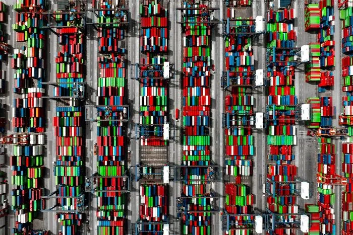Remarkable color photo capturing the world: an aerial view of a port filled with hundreds of colorful shipping containers.