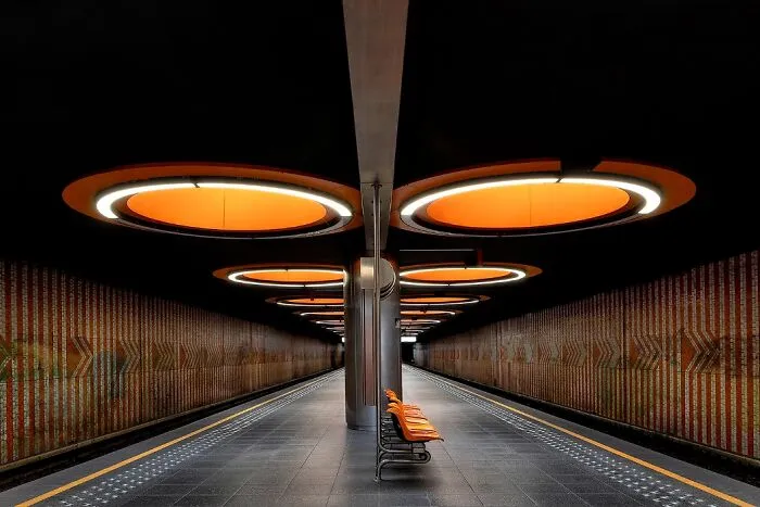 Remarkable color photo of an empty, well-lit subway station with unique orange circular lights, capturing the world.