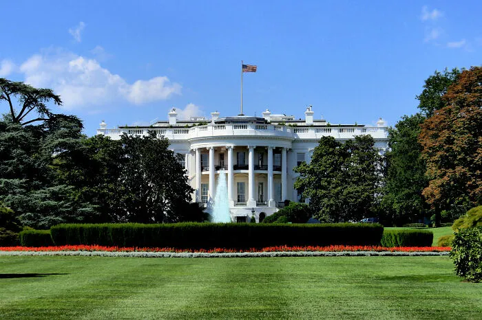 White House with a lush green lawn, trees, and a fountain, symbolizing key timeline facts of history.