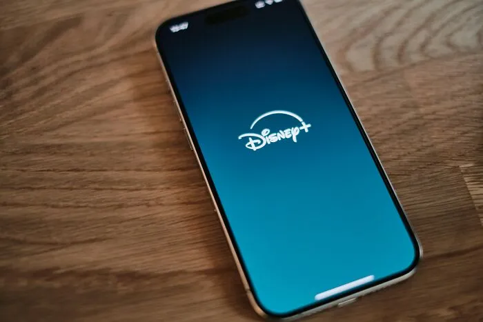 A smartphone displaying the Disney+ app, symbolizing entertainment choices among friends.