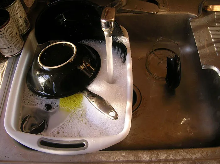 A sink full of soapy dishes, illustrating a common domestic activity that can highlight intercultural relationships.