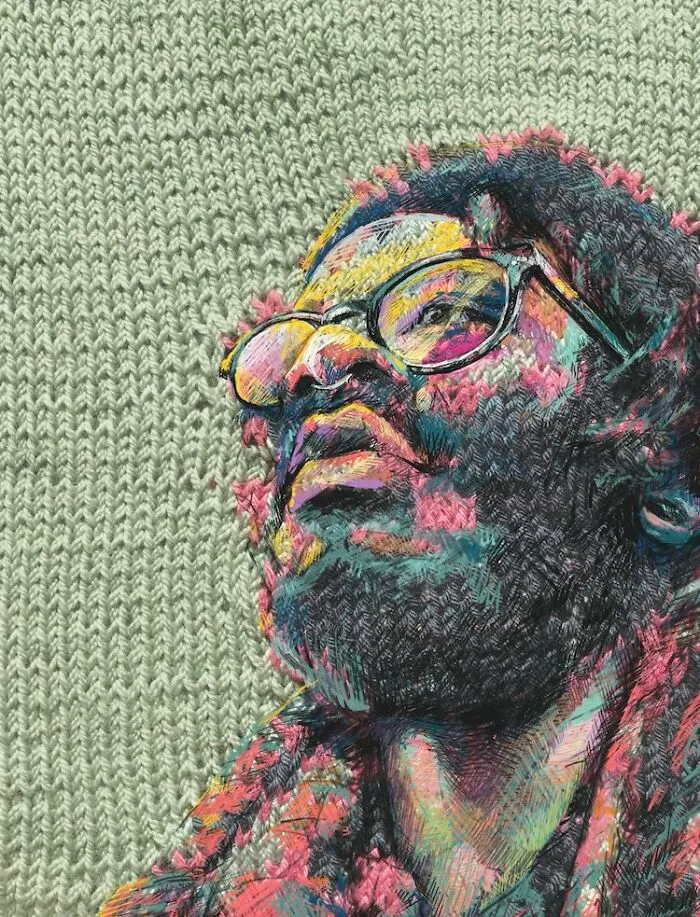 A man with glasses and a beard, looking upwards, rendered through traditional knitting and modern art.