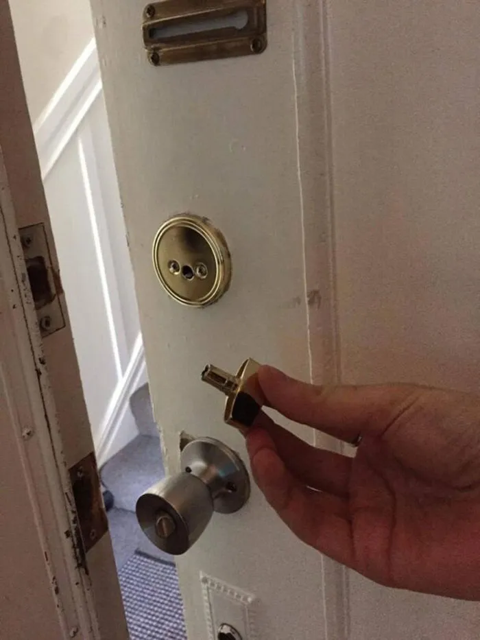 A hand holding a broken door lock, an Airbnb blunder that might have you booking a boring hotel room.