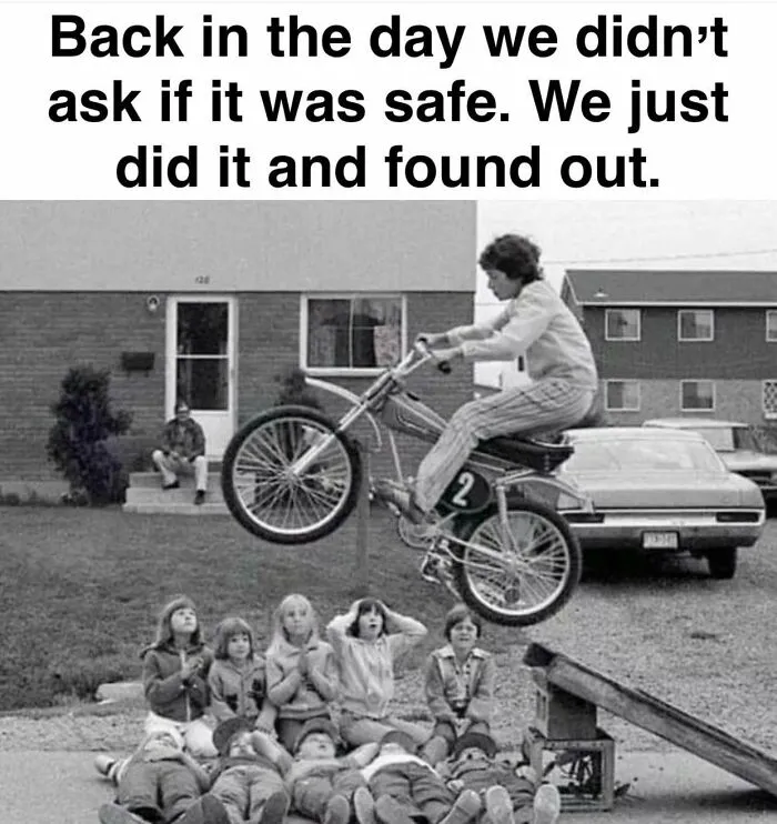 A black and white Gen X meme: a person on a motorcycle jumping over kids lying on the ground, showcasing 80s freedom.
