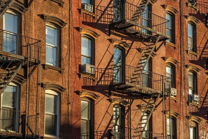 A building with fire escapes and windows, illustrating stories about guests who completely ignored basic house etiquette.