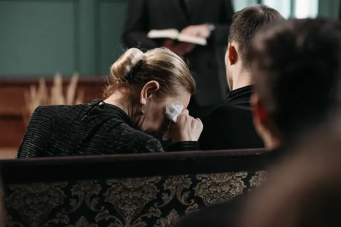 A woman crying during a funeral, symbolizing the harsh realities of being married.