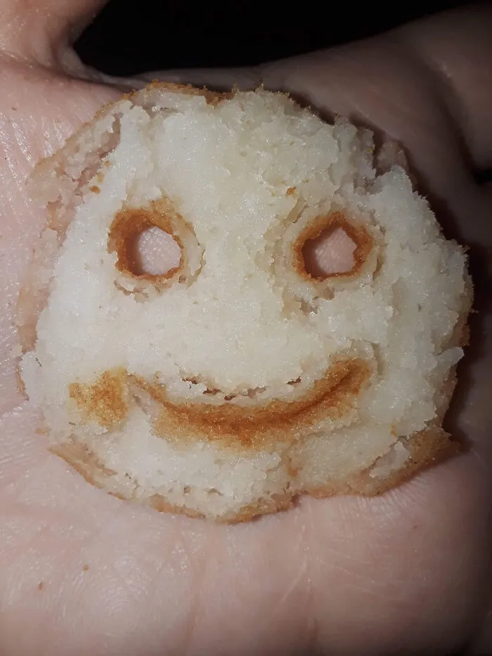 A burnt smiley-face cookie in a hand, representing a moment parents were terrified of their own children.