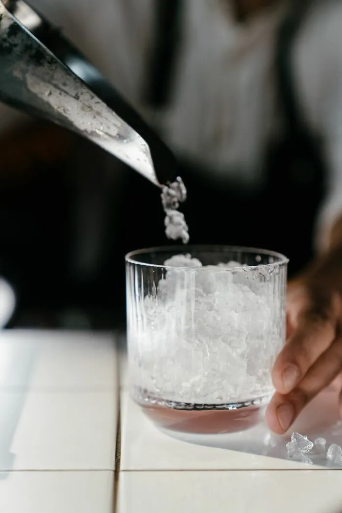 Crushed ice being scooped into a glass, illustrating a specific American habit.