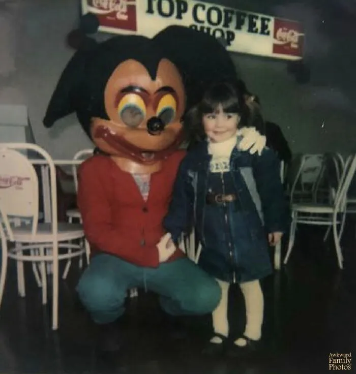 Awkward family photos of a smiling child with a slightly terrifying character mascot, a large bee, in a cafe.