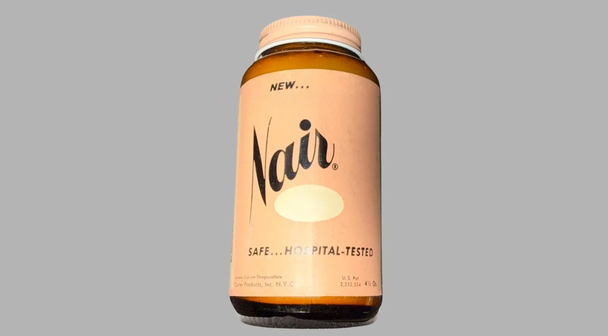 A vintage Nair bottle, featuring a peach-colored label with black text. A perfect example of a vintage item.